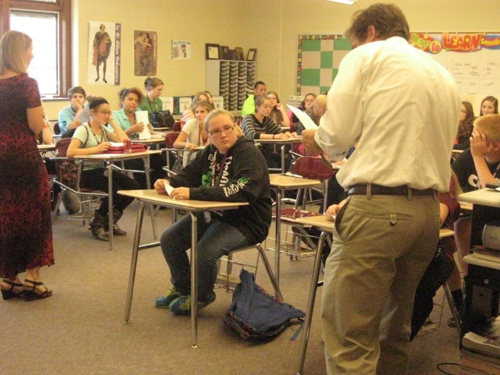 Helping a student, John King explains to a student what's going on at the literature magazine meeting in Wanda Pletcher's room on October 8, 2013.  John and Wanda are combining their groups, newspaper and literature magazines, into fundraising for a big New York trip at the end of the year.