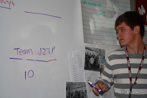 Ninth grader, Tyler Skelley, writes his score on the white board. These scores were from the teams for Jeopardy review.