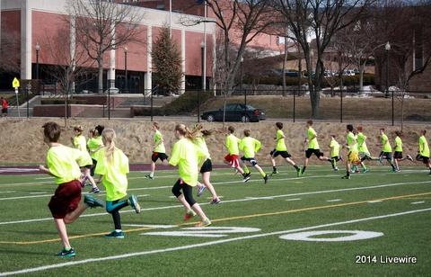 The seventh and eighth grade track teams finishes up their warm ups. Photo by Hannah Barr