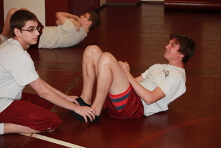 Photo By: Madison James 
Ninth grader Brady McCarthy works hard to get through sit ups. McCarthy was able to get above the president fitness award standard. 