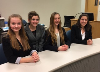 Jazzmine McCauley, Karlie Thompson, Raquel Dunio, and Caroline Danison sitting at the table waiting for the trial to begin.