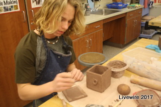 Get sculpting! Ninth grade student Jace Greene is working on the top to his project. His project was a clay box with a face on the front.