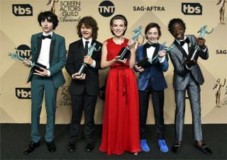 Finn Wolfhard, from left, Gaten Matarazzo, Millie Bobby Brown, Noah Schnapp, and Caleb McLaughlin pose in the press room with the awards for outstanding performance by an ensemble in a drama series for Stranger Things at the 23rd annual Screen Actors Guild Awards.