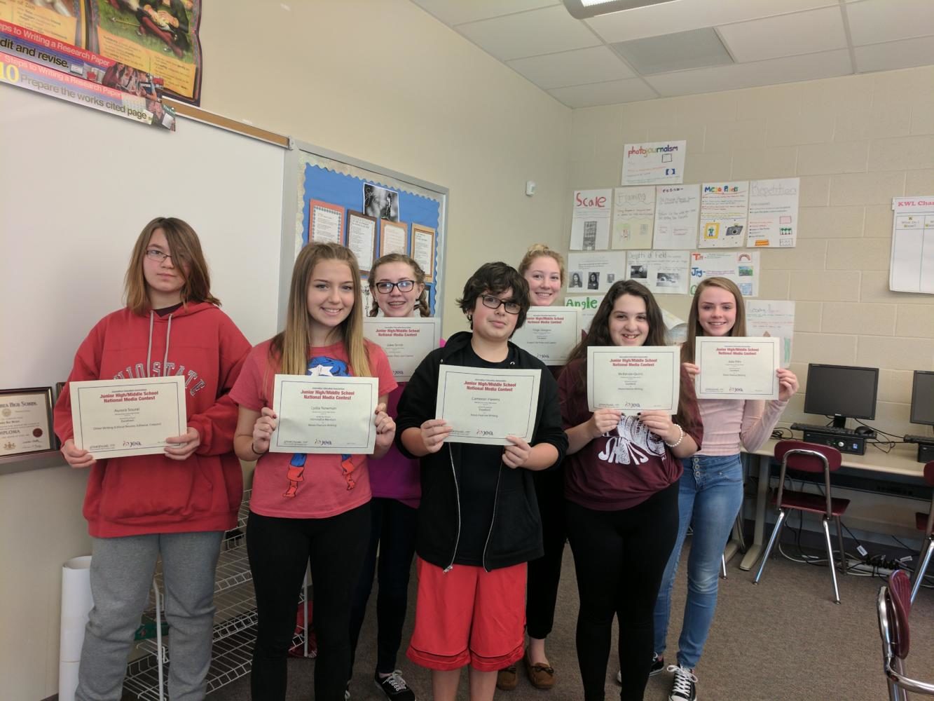 Aurora Soural, Lydia Newman, Jolee Smith, Cameron Havens, Paige Glasgow, Mckenzie Quirin and Julia Pitts display certificates recognizing their ratings for the National Media Contest. (pictured from left to right)