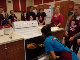 Yum! 9th grader Anna Batrus pulls a pizza out of the oven during the homemade pizza lab in foods class. Lab partner Kassie Clawson stands by to make sure Batrus is careful and doesn’t burn herself!

