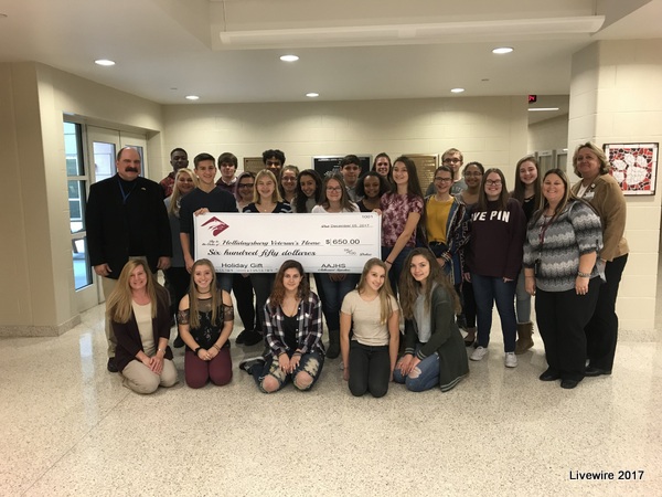 The ninth grade committee gathers together to hold up the check of $646.60.