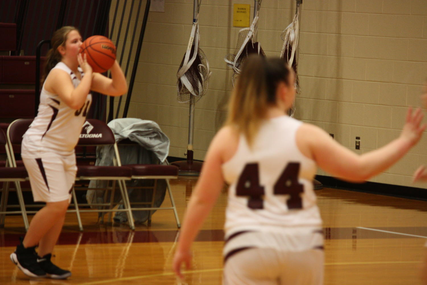 Shoot it! Eighth grade player Casey Kuhn takes a shot while practicing before the State College game as Cassidy Klock watches.The team continued to practice until their coach called a huddle.