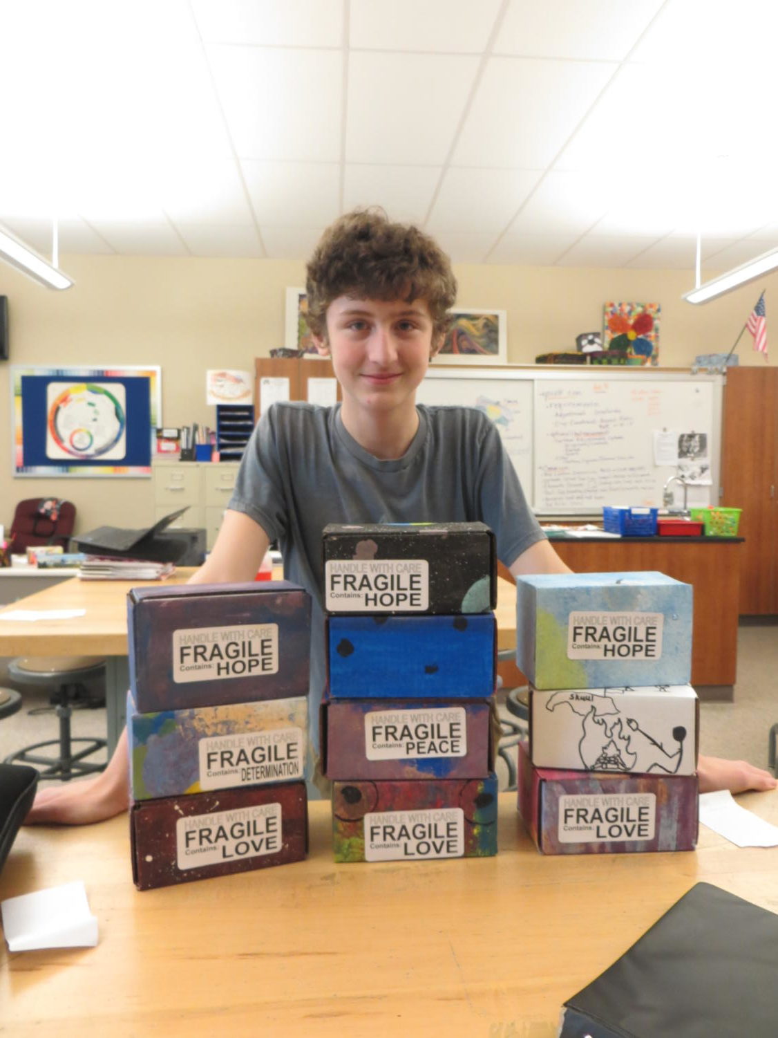 Love! Ninth grader Michael Herren stands behind peace boxes in Mrs.O'Roarks art class room.