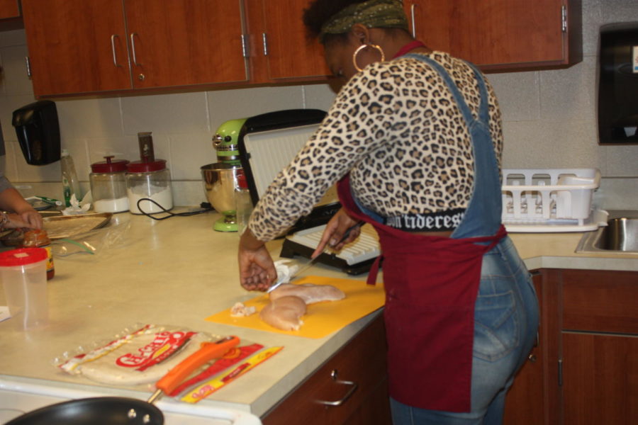 Slice away! Zyasiah Smith cuts raw chicken up. Smith cut off all the fat the was on the chicken before cooking it.