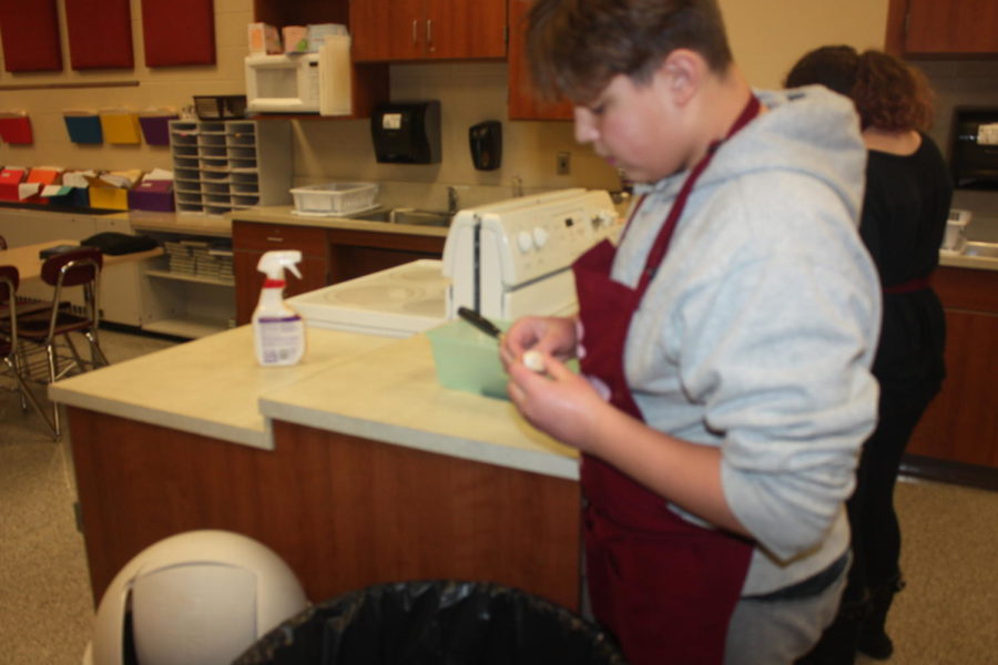 Peel apart! Landen Hauser peels the skin off a piece of garlic. Hauser partner for the project was Dynasty Covington.
