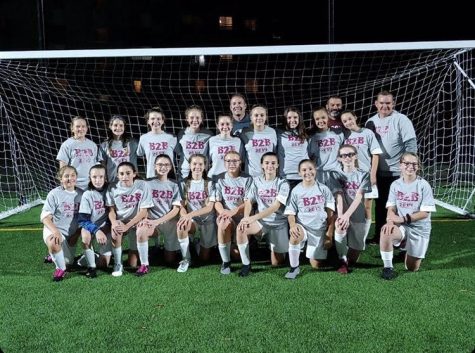 The girls' soccer team gathers with their coaches for a photo after another win is added to their undefeated streak. The past season for the girls' soccer team added their fourth undefeated season to their streak as they win against opposing teams.