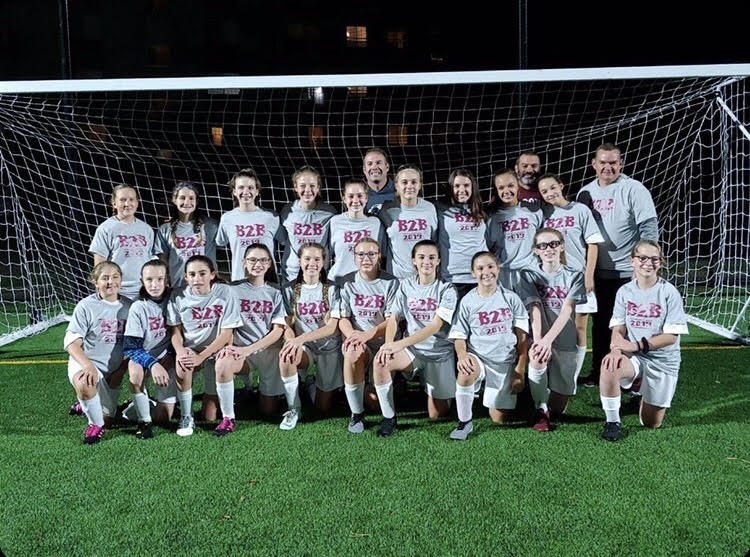 The+girls+soccer+team+gathers+with+their+coaches+for+a+photo+after+another+win+is+added+to+their+undefeated+streak.+The+past+season+for+the+girls+soccer+team+added+their+fourth+undefeated+season+to+their+streak+as+they+win+against+opposing+teams.