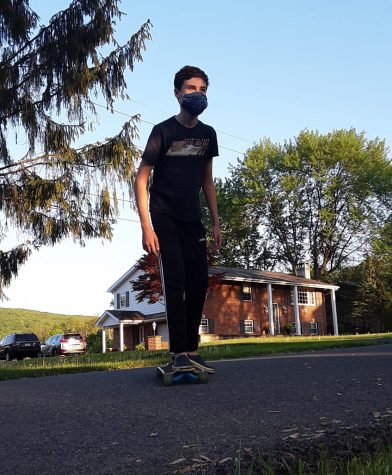 On the move! Sixth grader, Jonathan Slusser, rides on a skateboard earlier this week. He skated long before skateboarding became more popular.  Slusser said, I think that it is convenient to carry around, fun to ride and a great way to hangout with friends.