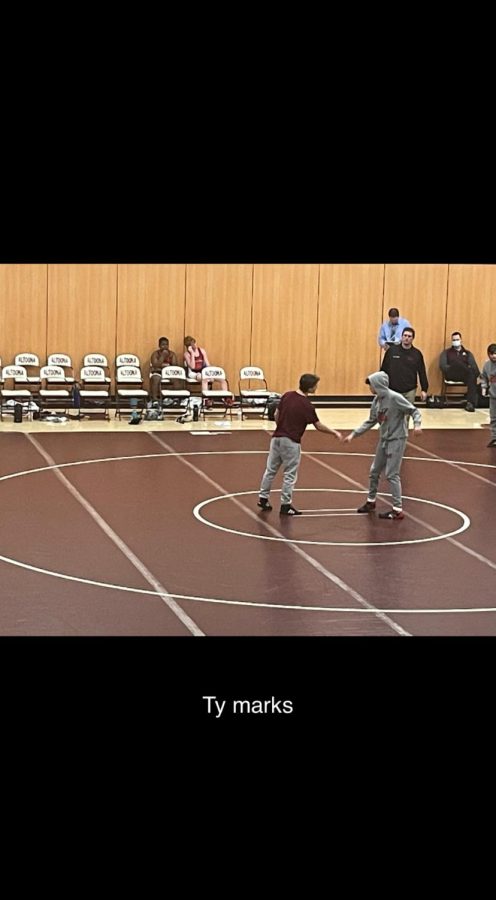 Eighth grader Ty Marks shakes hands with the opponent he will be wrestling against.