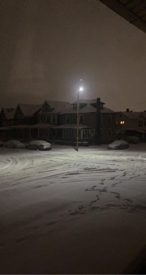 The street lights deflecting down on the snowy roads. 