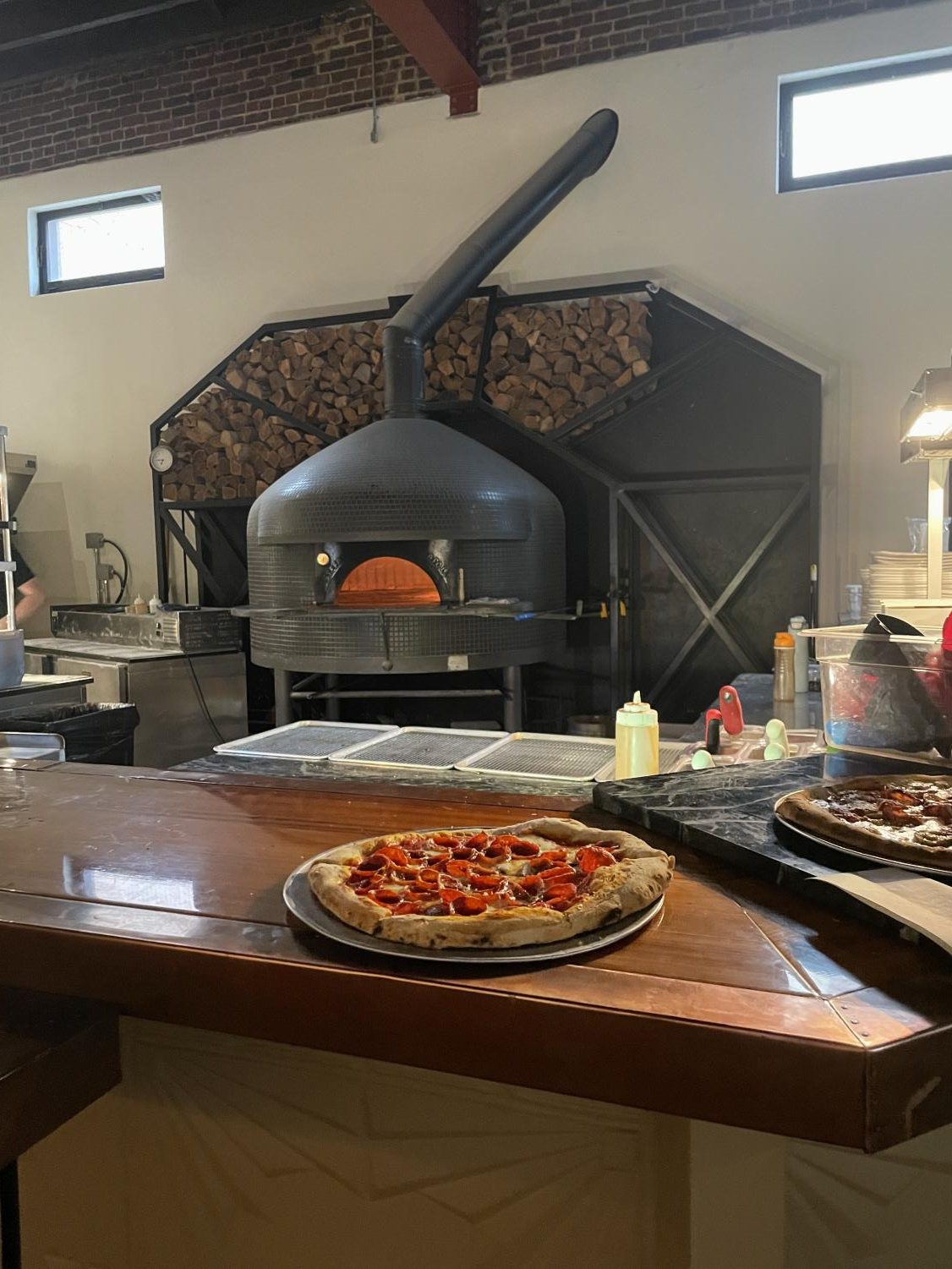 Modern kitchen. The delicious pizza comes baked fresh out of the oven. This delicious pizza was waiting to be taken to a table.