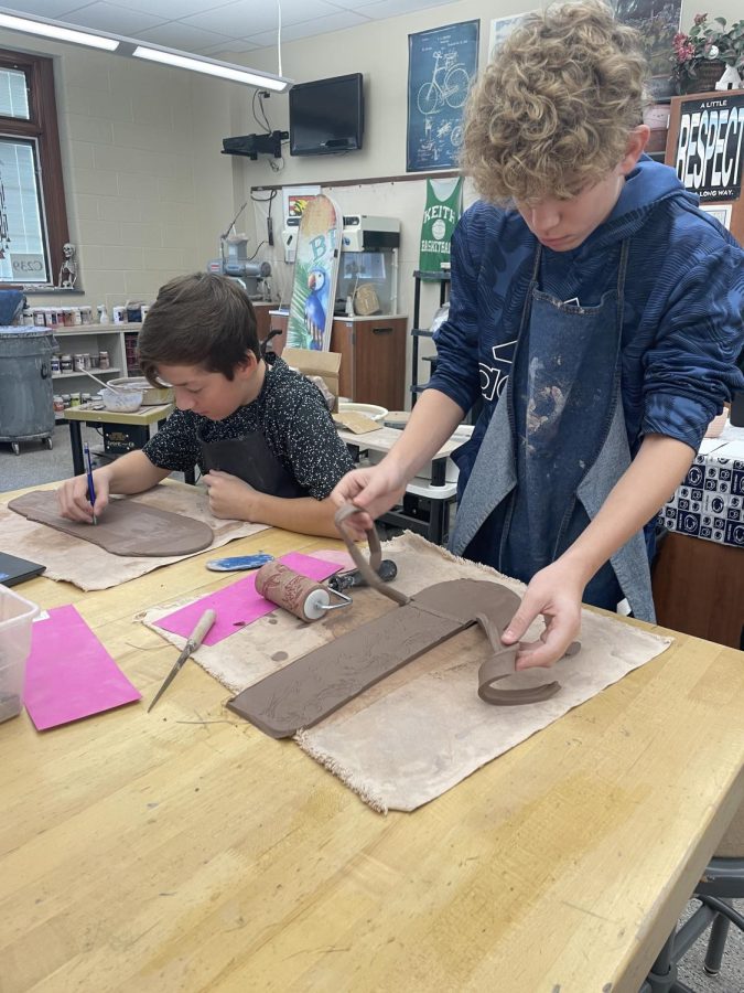 Eighth+graders+Talan+Palladini+and+Caiden+Cochran+are+working+on+their+mugs.+They+were+very+intricate+in+the+rest+of+their+design.