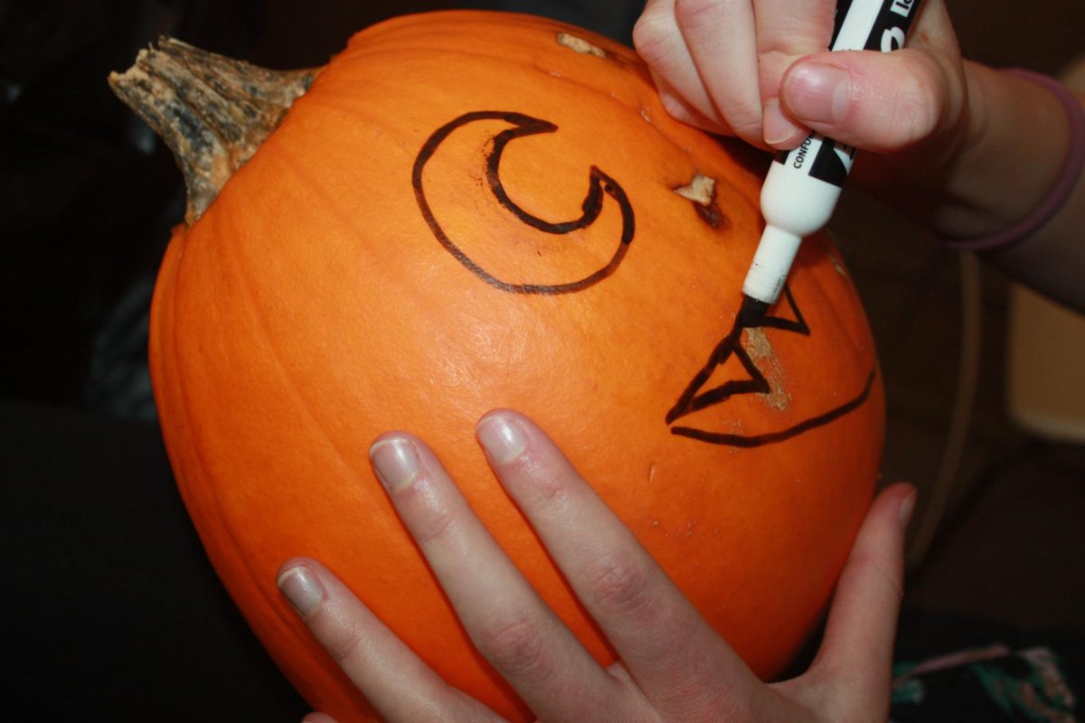 Bring out the markers! Eighth grader Ella Heverly sketches her design on her pumpkin. Heverly used smart thinking and pulled out an Expo marker so she would know where to carve.

It was fun to take a break from news writing and get into the Halloween spirit, said Heverly.