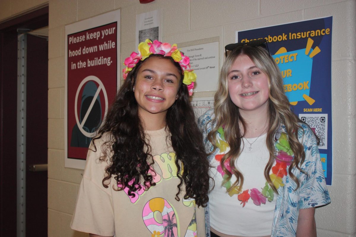 Eighth graders Jayla Bronson and Leah Rinehart pose in Hawaiian outfits.