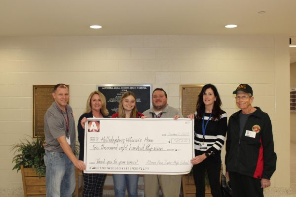 Veterans donation! Sixth grade attendance clerk Shaun Kuhns, head principal Lori Mangan, eighth grade math teacher Madelyn Ardrey, eighth grade math teacher Jason Hatch, commandant Chrissy Dambeck and resident Robert Fink took a lovely picture with the donation the school was able to give this year. This year the donation was extended due to a short week of school. This year there was about four extra days for the collection according to eighth grade English teacher John Garlick.
