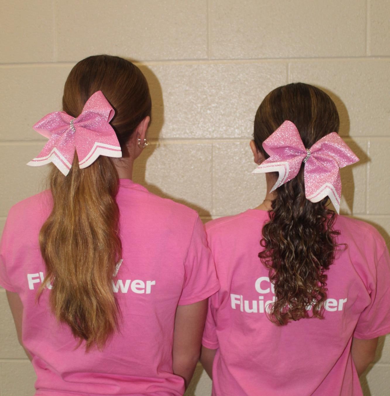 Pink out! Eighth grade cheerleaders Nina Dunio and Kendyl Carney are ready for the football game wearing their pink bows and T-Shirts. Other cheerleaders showed their spirit by also wearing their bows and T-shirts to school.