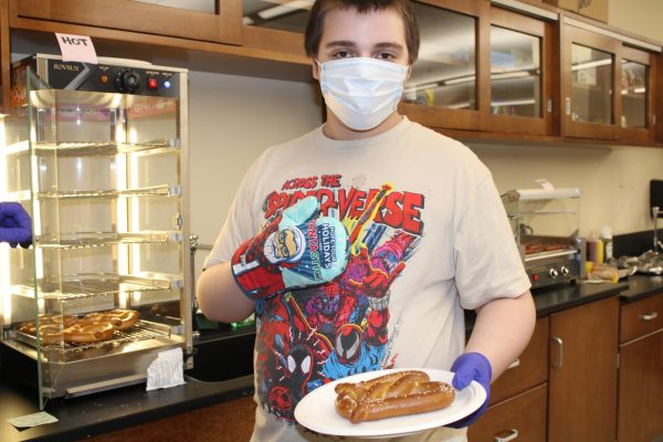  Speedy service!  Estep takes the pretzel out of the warmer. He  prepared to go deliver it.  "I enjoy cooking in general, but I enjoy making sure the orders are corrected and then delivering them to the teachers and principals," said Estep.