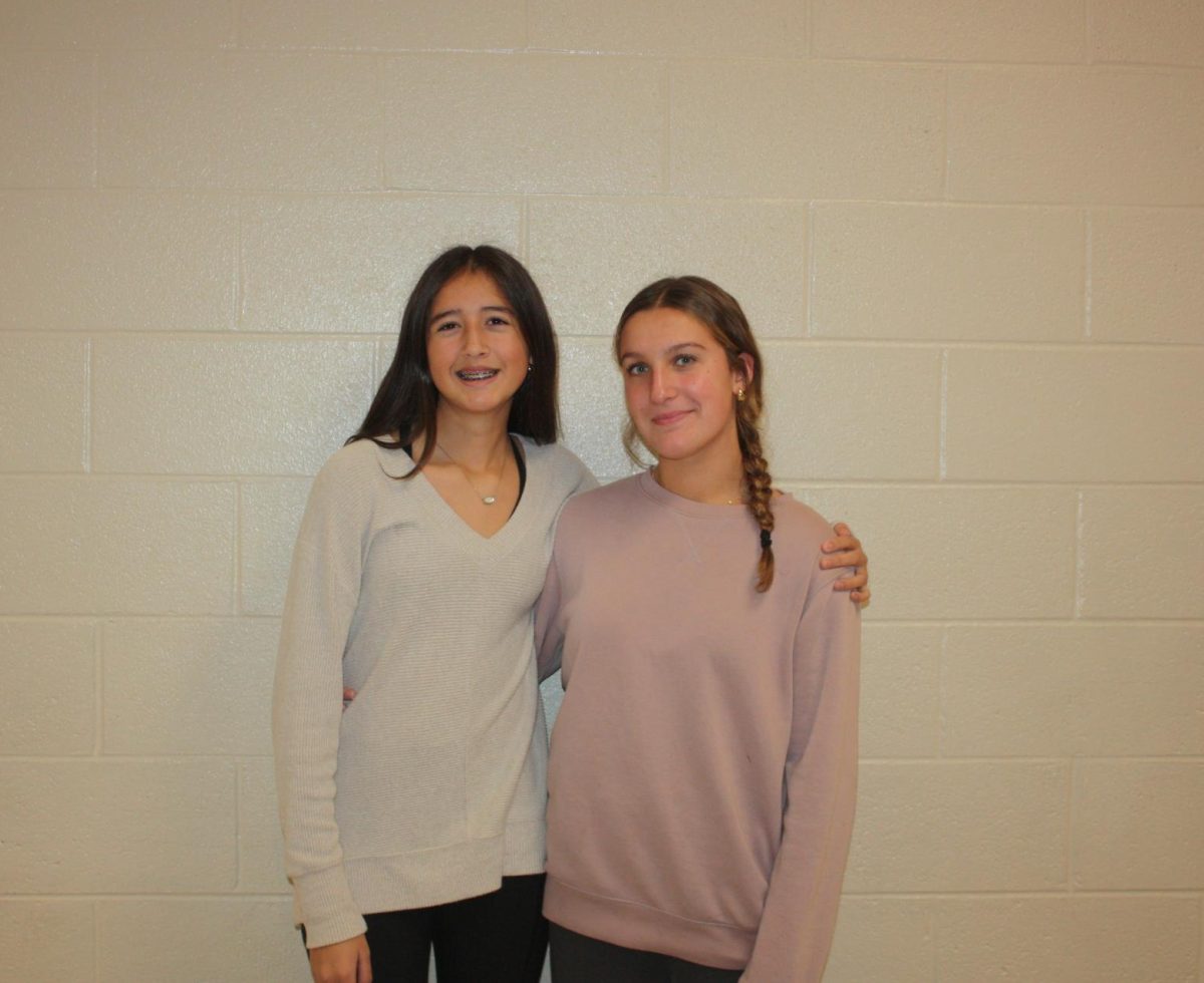 Smile! Eighth graders Leah Nedimyer and Mikayla Patterson pose for a picture after working hard on the yearbook.