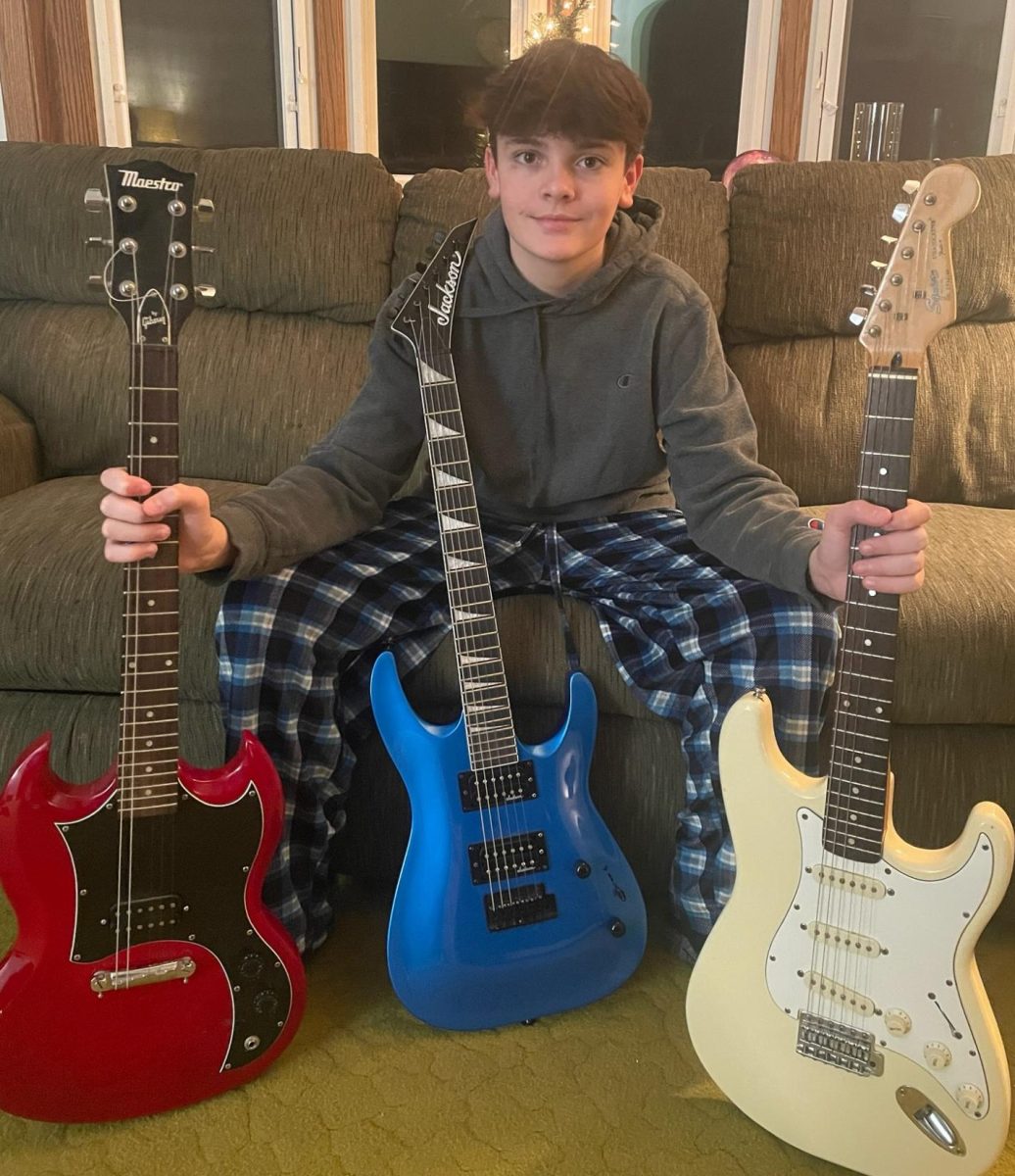 Eighth grader Ethan Shoeman showing off his three guitars.