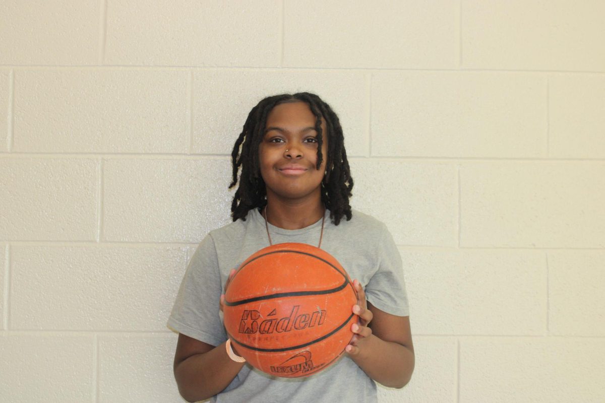 Smile! Eight grader Kharisma Davis poses for a photo. This is her last year here, and she is a really good basketball player. " I love playing basketball," said Davis.