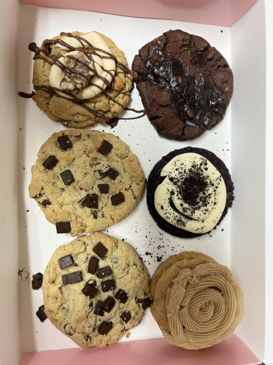 Yum! Crumbl Cookies' featured cookies for its grand opening! In the box there are two Semi Sweet Chocolate Chunk cookies,  a Brownie Batter cookie,  a Churro cake cookie, a peanut Butter Snickers cookie and a Chocolate Oreo Crumb cookie!